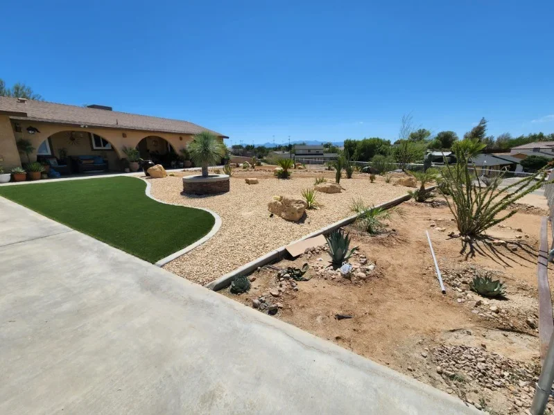 Synthetic turf, gravel beds, desert plants, concrete patio, and fire pit in completed landscape design